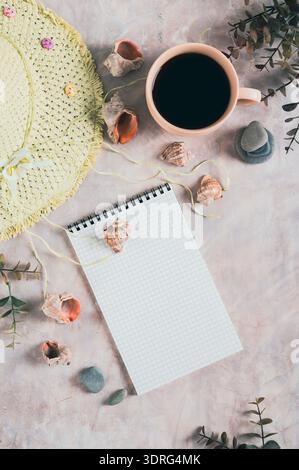 Notebook, beach hat, shells and stones on the table top and vertical view Stock Photo
