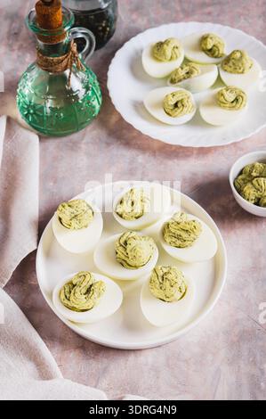 Avocado deviled eggs for appetizer on plate on table vertical view Stock Photo