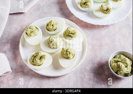 Avocado deviled eggs for appetizer on plate on table Stock Photo