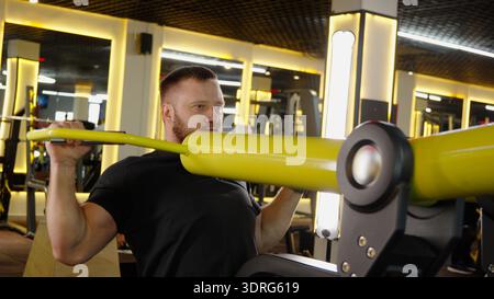 Man doing chest press on machine in gym Stock Photo