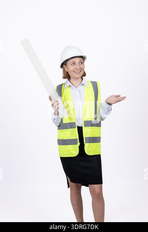 Female engineer in safety vest holding blueprints Stock Photo