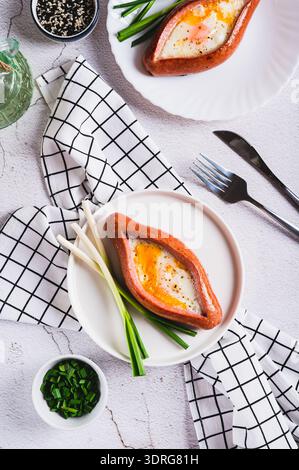 Sausage filled with fried egg and garlic on a plate on a table top and vertical view Stock Photo
