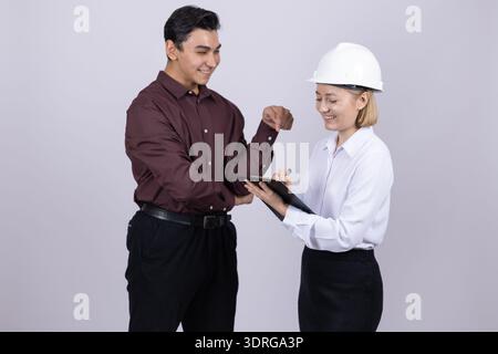 Team of construction workers shaking hands in studio Stock Photo