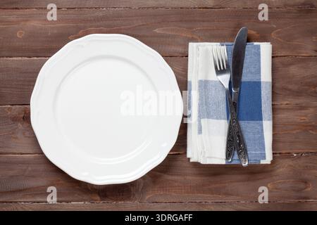 Empty plate and silverware over wooden table Stock Photo