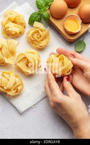 Chef preparing homemade tagliatelle pasta with eggs and basil Stock Photo