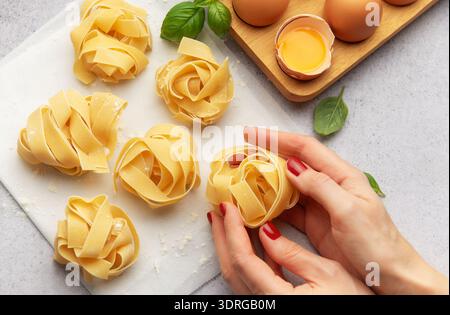 Chef preparing homemade tagliatelle pasta with eggs and basil Stock Photo