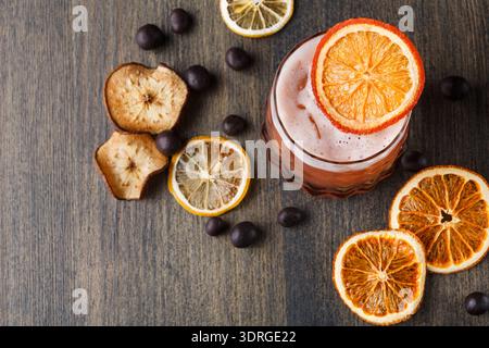 Drink With Dried Citrus and Chocolate Balls on Wooden Table in Bright Setting Stock Photo