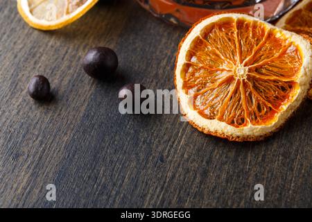 Dried Orange Slices and Cacao Beans on a Wooden Table With a Glass Jar in View Stock Photo