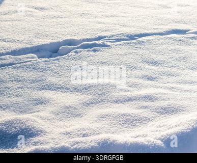 A close up of a snow covered surface with footprints or a path winding through it Stock Photo