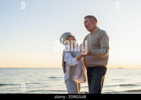 Keep moving. Romantic senior mature couple dancing together on beach outdoor recreation. Happy smiling family retired man woman Stock Photo