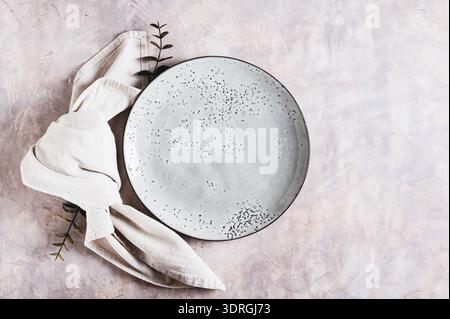 Empty gray ceramic plate and napkin on light background top view Stock Photo