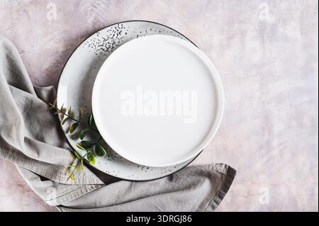 Pair of empty ceramic plates with napkin on gray background top view Stock Photo