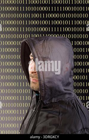 Hacker hides behind a hood Stock Photo