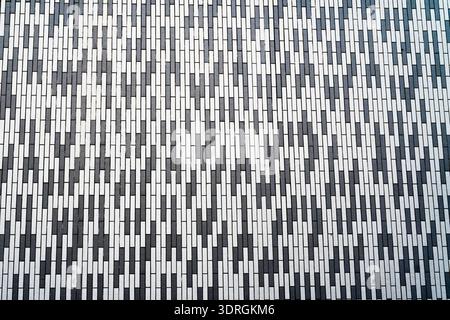 Modern white and black brick wall pattern with geometric design on urban building facade Stock Photo