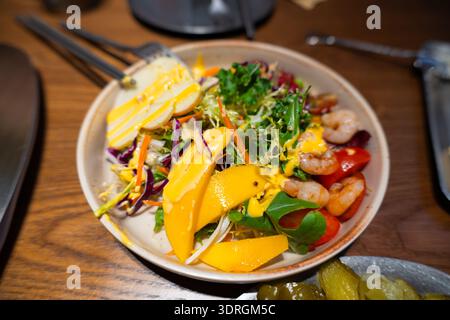 Vietnamese Summer Roll Salad with Shrimp, Mango, and Fresh Herbs on Wooden Table Stock Photo