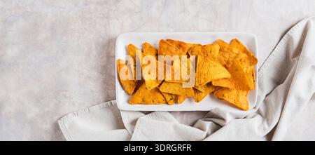 Crispy nachos in spices on a plate on the table top view web banner Stock Photo