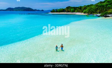 Couple enjoying a romantic walk on a scenic tropical beach at sunset in Thailand Stock Photo