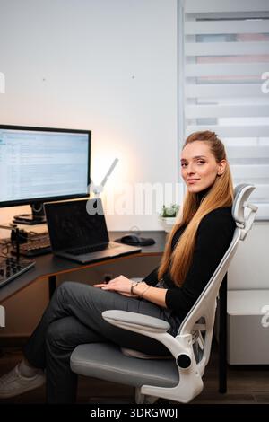 Young woman working from home office smiling at camera Stock Photo