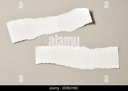 grey color pieces of paper with irregular, ripped, and torn edges background. The rough, jagged edges of the texture paper Stock Photo