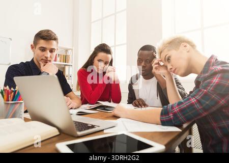 Group of Students Focused on Their Project While Working on a Laptop at a Table Stock Photo