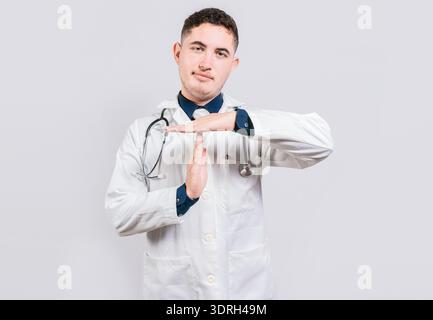 Young doctor gesturing time out isolated. Latin doctor making time out gesture with palms on isolated background Stock Photo