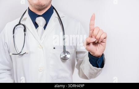 Unrecognizable doctor pointing up. Hand of doctor pointing up. Doctor finger pointing up with text space Stock Photo