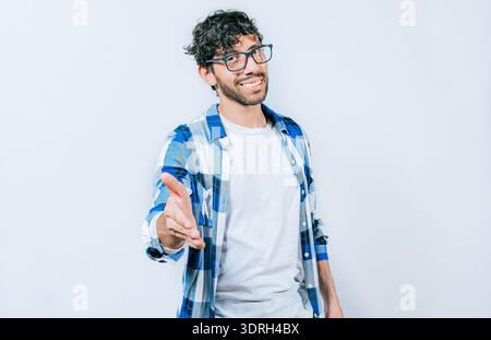Smiling young man shaking his hand at the camera. Guy in glasses shaking hands at camera isolated Stock Photo