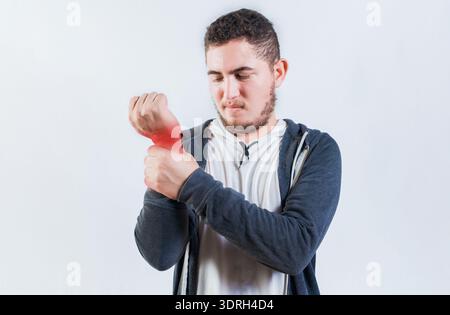 Suffering young man with pain in hand joints isolated. Person with arthritis pain rubbing hand Stock Photo