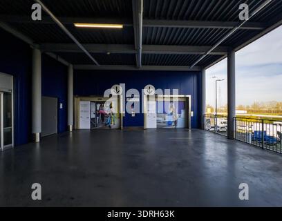 Covered outdoor terrace of an IKEA store in Italy featuring two elevators with branded graphic doors set against a bold blue wall with Italian "Tutti Stock Photo