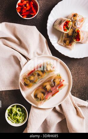 Delicious spring rolls with vegetables and mushrooms in rice paper on a plate top and vertical view Stock Photo