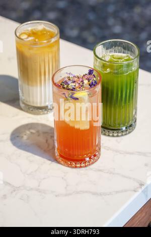 Assorted summer lemonades in glass jars with fresh fruits, ice, and garnishes Stock Photo