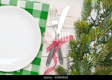 Empty plate, silverware and christmas tree. View from above over white wooden table background Stock Photo