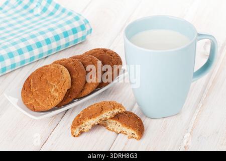 Cup of milk and gingerbread cookies on white wooden table Stock Photo