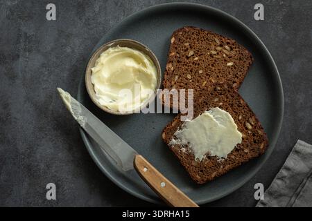 Freshly baked homemade dark rye bread with sunflower seeds, dark background,  top view Stock Photo