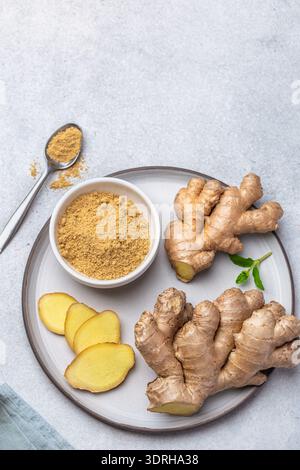 Fresh ginger root and  ginger powder  on plate, top view Stock Photo