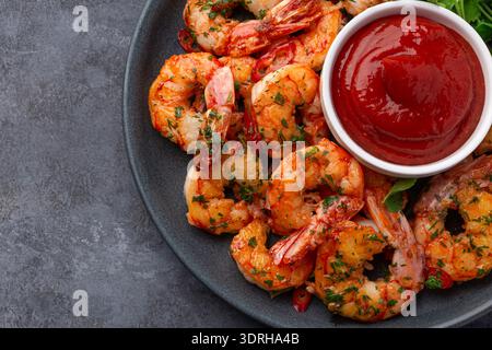 Close up of shrimps with  tomato sauce, top view, dark background Stock Photo