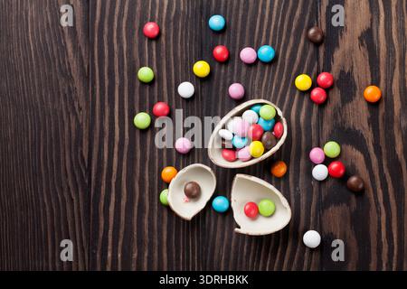 Colorful candies and chocolate egg on wooden background. Top view with copy space Stock Photo