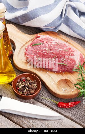 Raw beef steak and spices on wooden table Stock Photo
