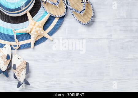 Beach accessories. Flip flops, hat and starfish on wooden background. Top view with copy space Stock Photo