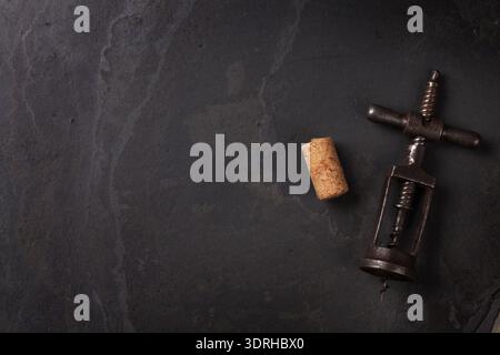 Vintage corkscrew and cork on stone table. Top view with copy space Stock Photo