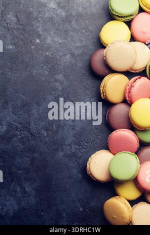 Colorful macaroons on stone table. Sweet macarons. Top view with copy space for your text. Retro toned Stock Photo