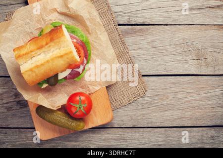Sandwich with salad, ham, cheese and tomatoes on cutting board. Top view with copy space Stock Photo