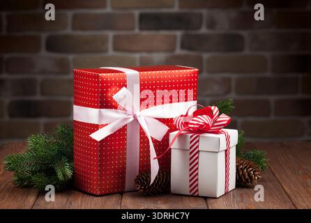 Christmas gift boxes and fir tree branch on wooden table Stock Photo