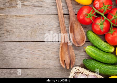 Fresh ripe vegetables and utensils on wooden table Stock Photo