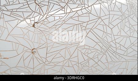 Cracked and peeling white plastic surface with intricate fracture patterns Stock Photo