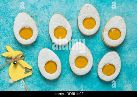 Sweet and tasty Easter linzer egg cookies with lemon jam filling. Blue background, top view Stock Photo