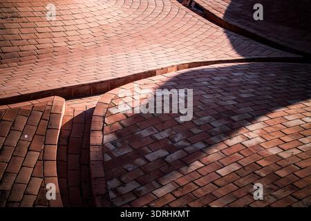 Curved terracotta brick roof tiles forming waves. Malaga Cathedral exterior. Malaga, Spain. Geometric pattern of traditional clay tiles and shadows. A Stock Photo