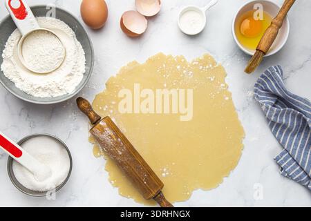 Making dough for pie or tart with rolling pin , baking and cooking concept Stock Photo