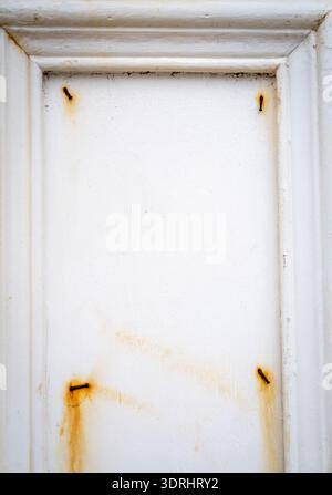 Rusty nails on a white wooden frame with peeling paint Stock Photo