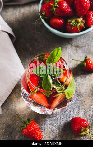 Wellness detox drink with strawberries and basil in glasses on table vertical view Stock Photo